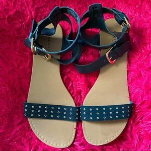 Black flat sandals with gold accents